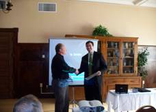 Matthias Hilger presenting Patrick Madden with information on Sister Cities of Jasper, Inc.